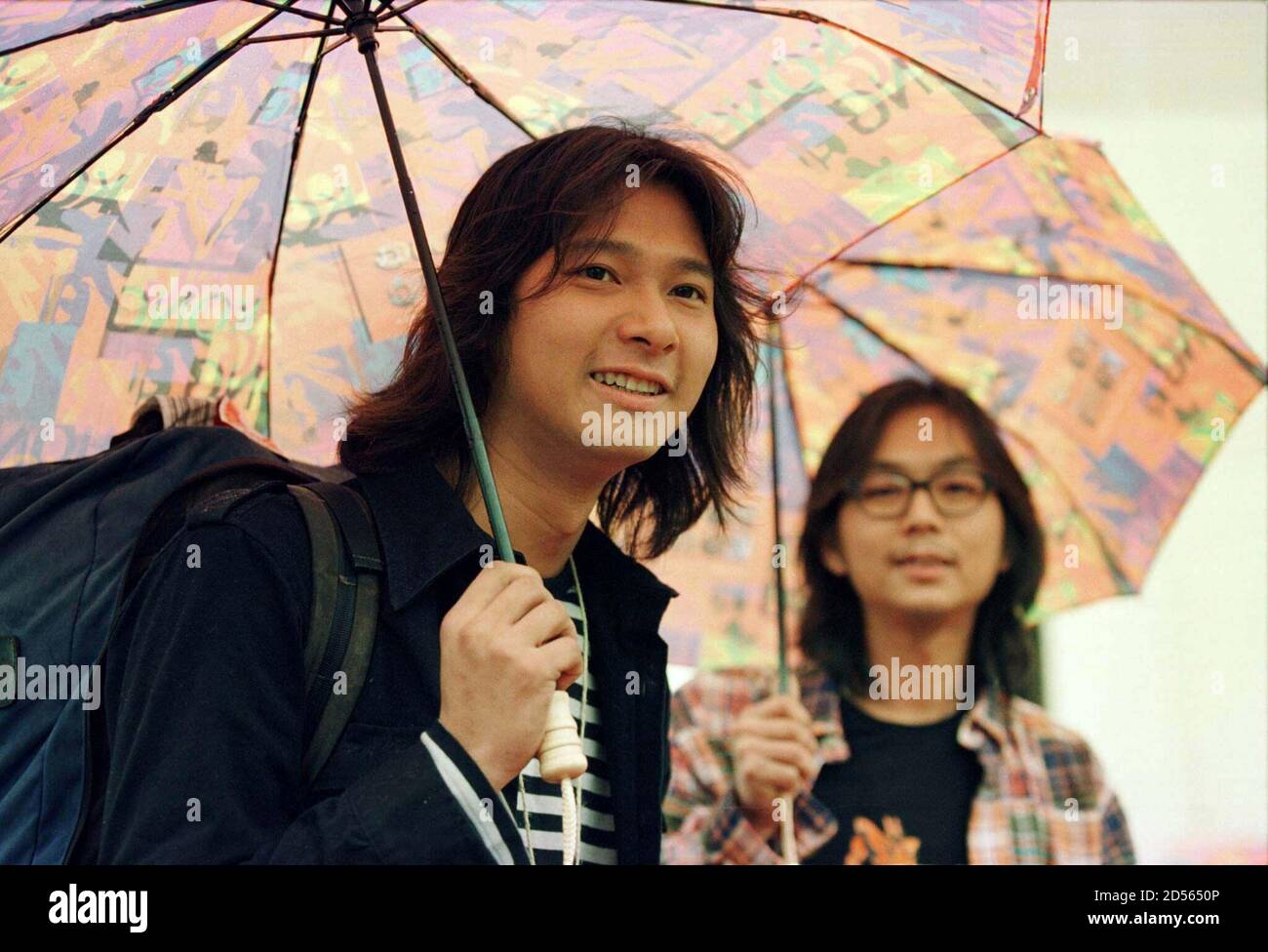 Twenty-two-year-old Takashi Ito (L) from Japan and 26-year-old Tse Chiu-yan  from Hong Kong are appointed Hong Kong Goodwill Ambassadors by the Hong  Kong Tourists Association during a ceremony in the rain December