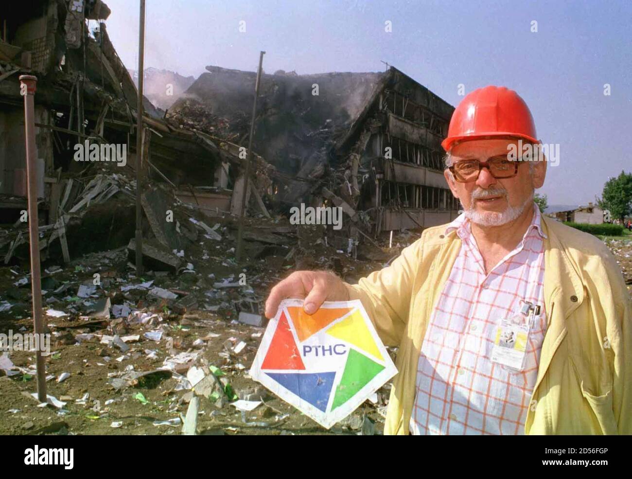 A TV Novi Sad employee holds up the logo in front of stations destroyed,  smouldering building after NATO missiles hit it during May 26 night/air  campaign on Miseluk hill overlooking Novi Sad.