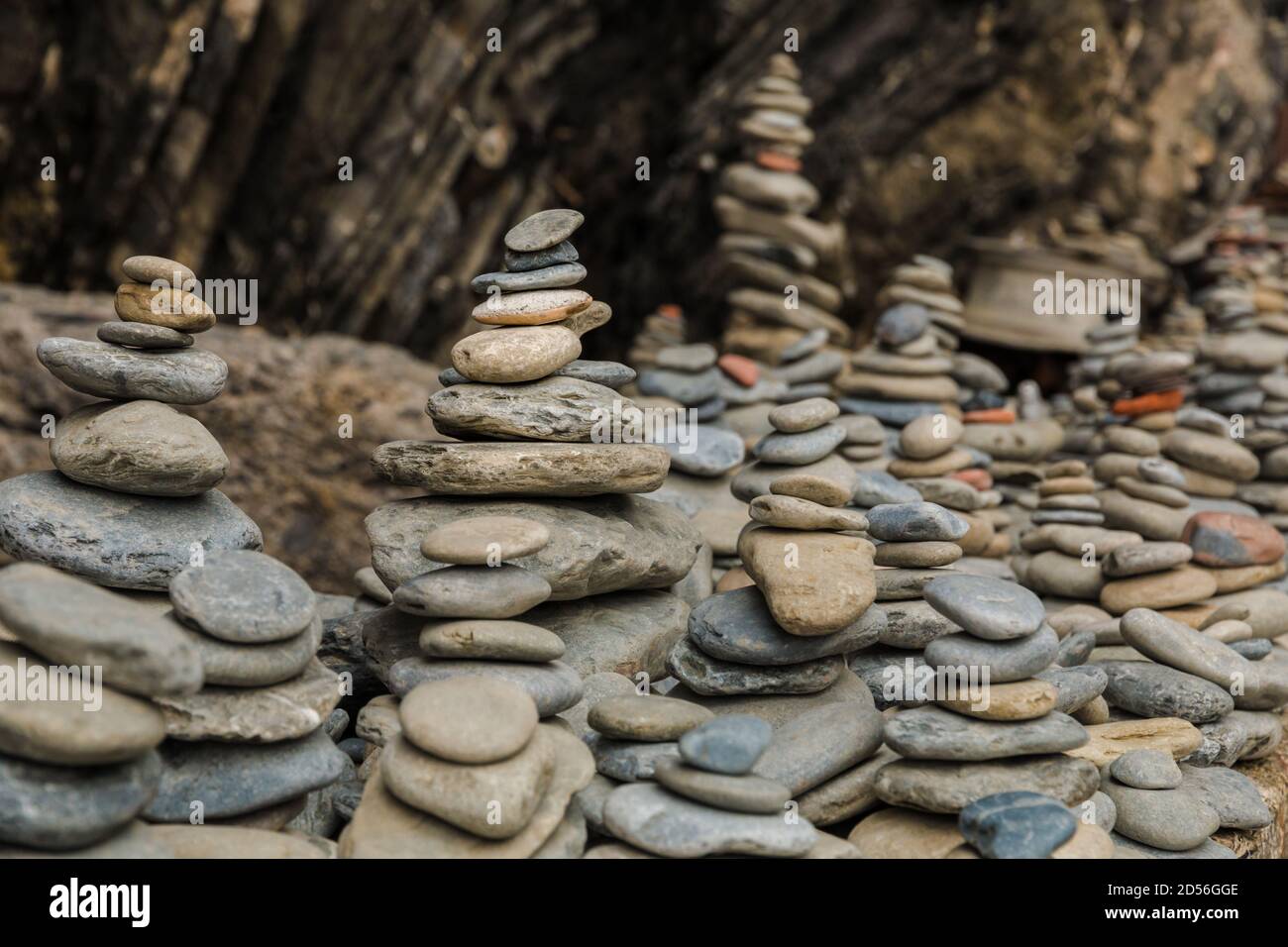 Beautiful close-up view of several stacked stones in a row on an outcropping rock at the entrance of the rugged pebble beach on the east coast of... Stock Photo