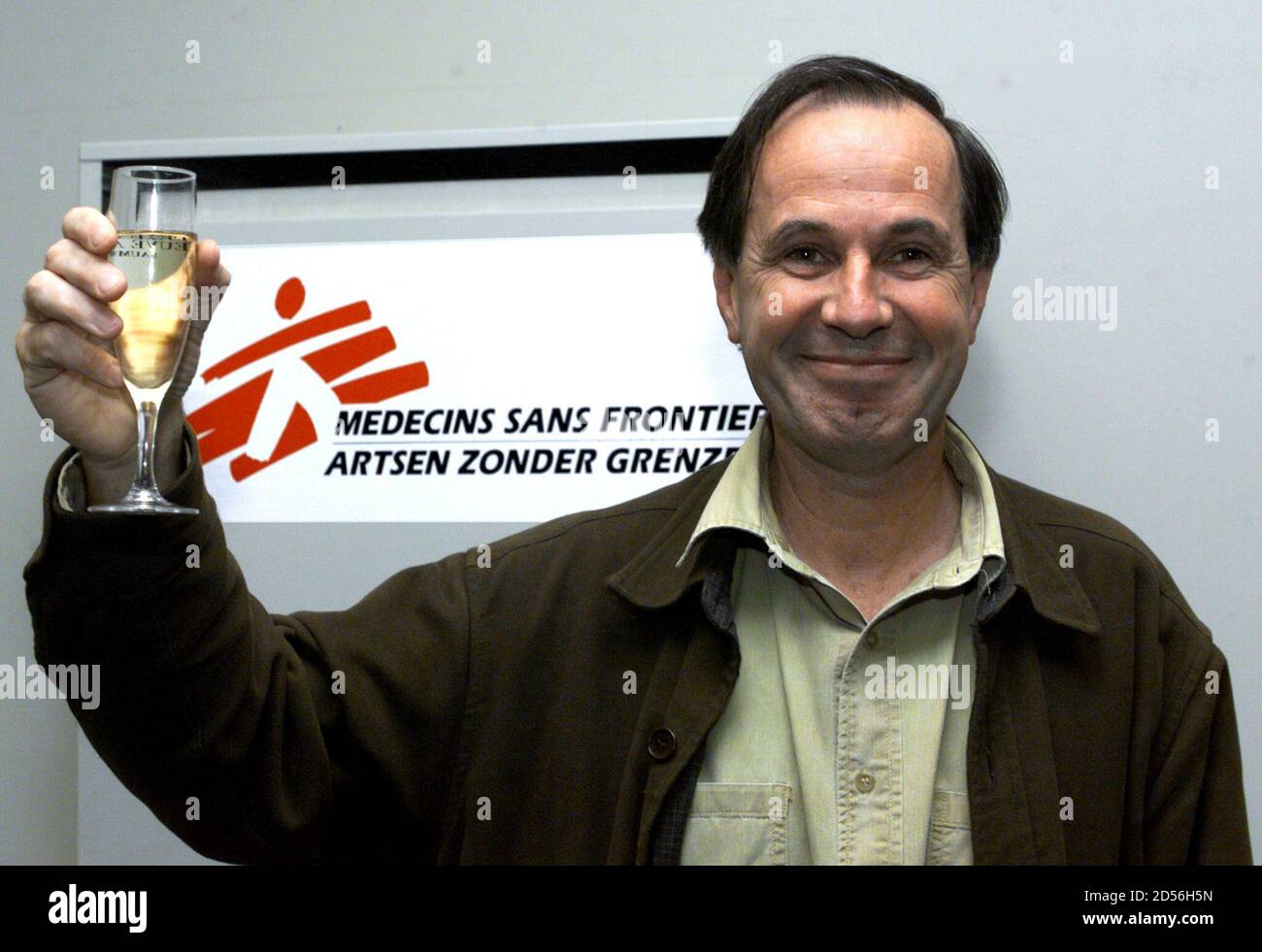 Jean-Marie Kindermans, General Secretary of Aid group Medecins sans  Frontieres (Doctors without Borders) International, holds a glass of  champagne at MSF's Brussels headquarters October 15, moments after he was  announced MSF won