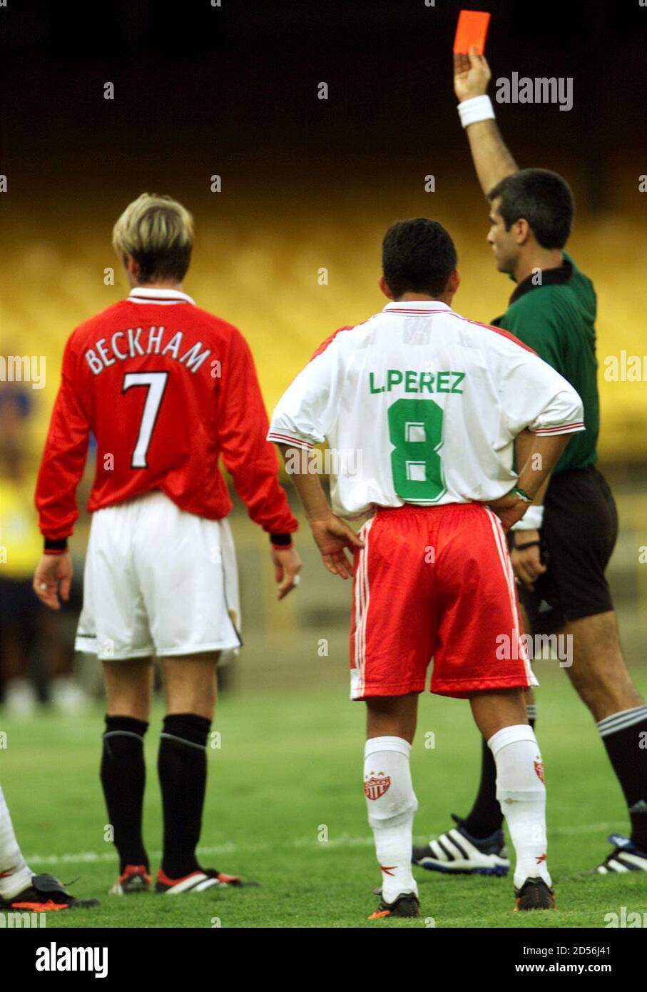 Midfielder David Beckham of Manchester United (L) receives a card and is sent off by referee Horacio of Argentina for a high challenge against Jose Milian of Necaxa, during the