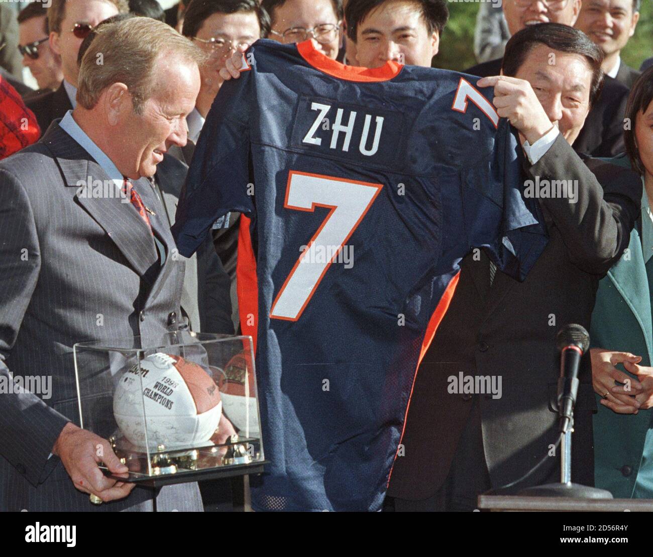 Chinese Premier Zhu Rongji (R) shows off a football jersey with his name on  it, but Denver Broncos quarterback John Elway's number, at the Broncos  headquarters facility in Englewood, Colorado April 10