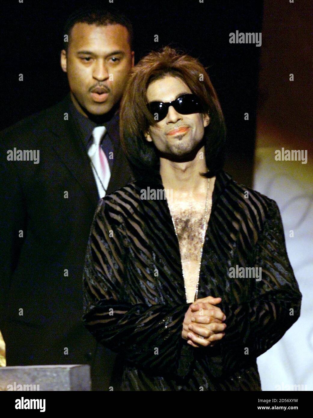 'The Artist' formerly known as Prince, accompanied by his bodyguard, listens to the applause of the crowd after being named Male Artist of the Decade at the 14th annual Soul Train Music Awards March 4. Stock Photo
