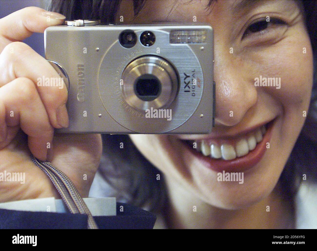 Canon Inc employee Yukiko Okamoto strikes a pose with what they say is "the  world's smallest and lightest 2-megapixel-class optical zoom digital camera,"  IXY DIGITAL at an unveiling at a Tokyo hotel