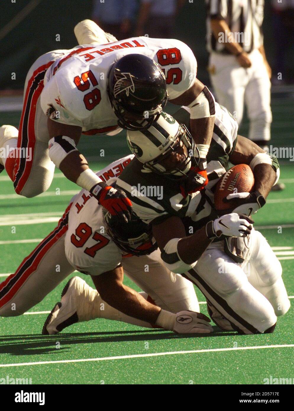 New York Jets' running back Curtis Martin (R) is tackled after gaining a  first down by Atlanta Falcons' defenders Cornelius Bennett (L) and Jessie  Tuggle (top) during the first quarter of their