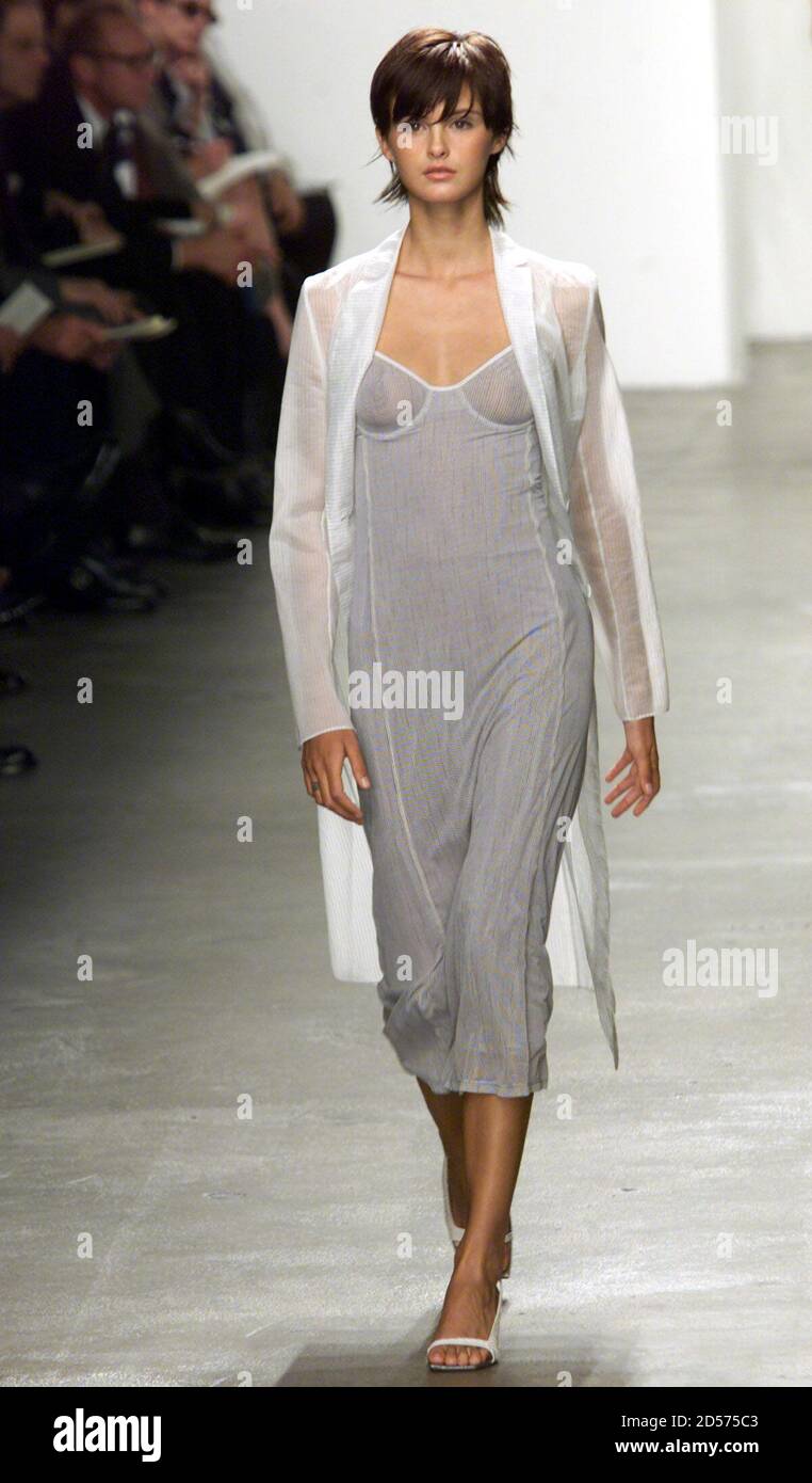 A model for designer Calvin Klein wears a white sheer silk coat and a  blue/grey linen dress from the Calvin Klein Spring 2000 Collection during  the showing of the Collection in New