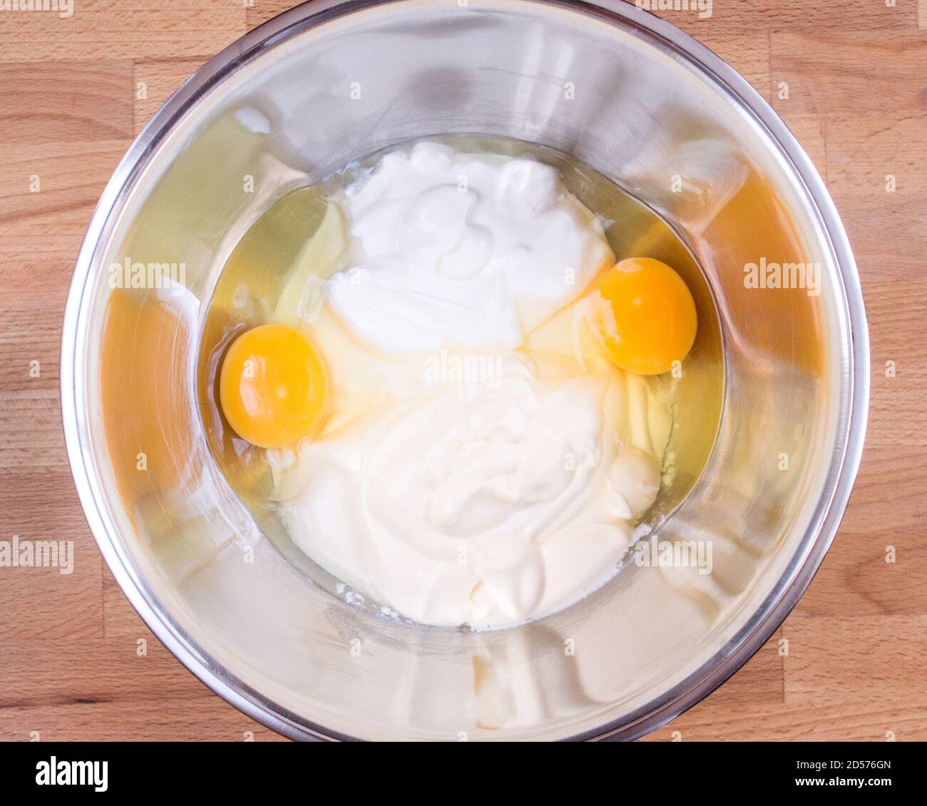 Sour cream, mayonnaise, raw eggs in a bowl. Ingredients for making pie