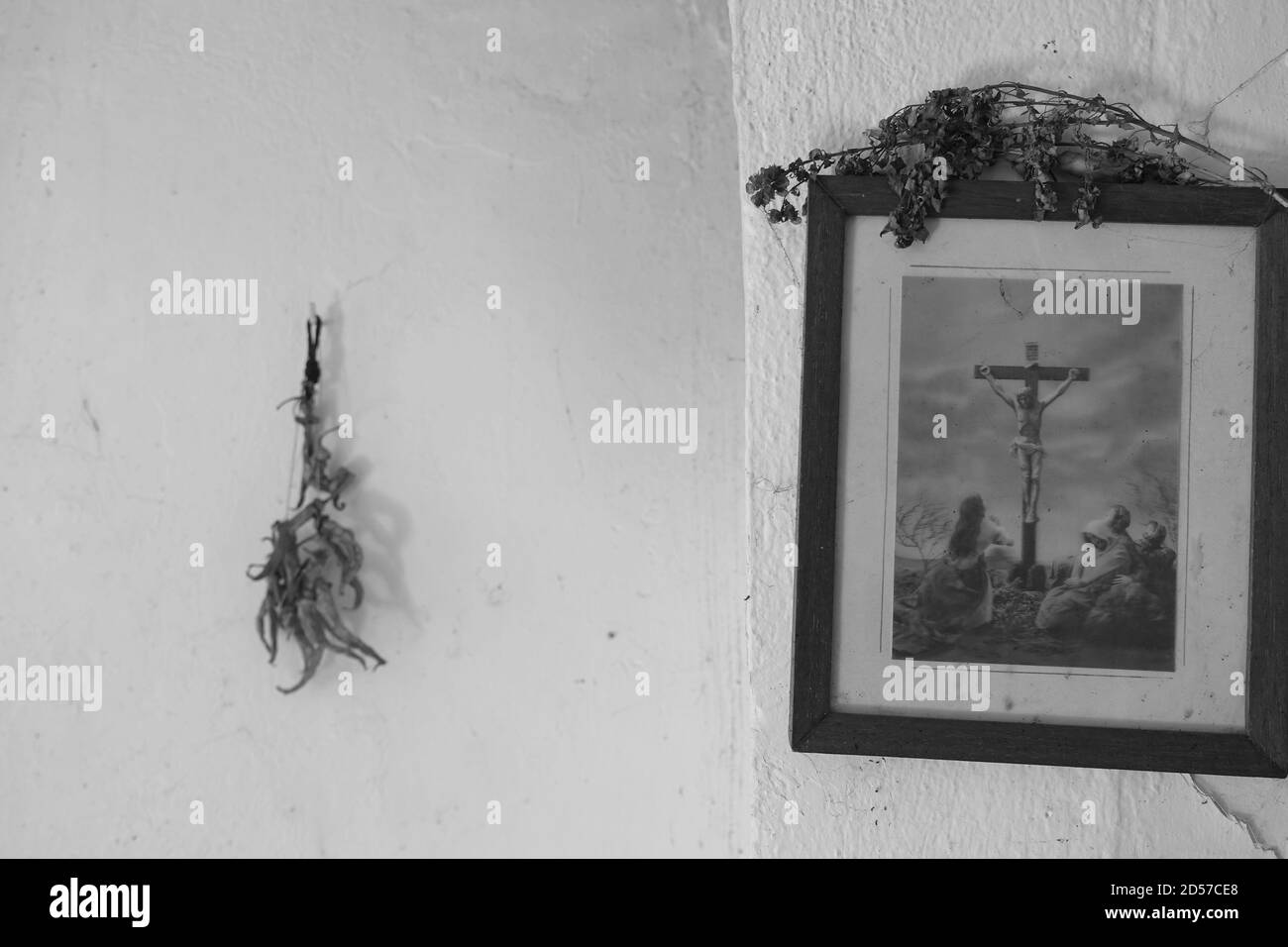 Athens, Greece - September 12, 2020: Desiccated flowers on vintage framed picture with depiction of the crucifixion of Jesus and dried herbs hanging o Stock Photo