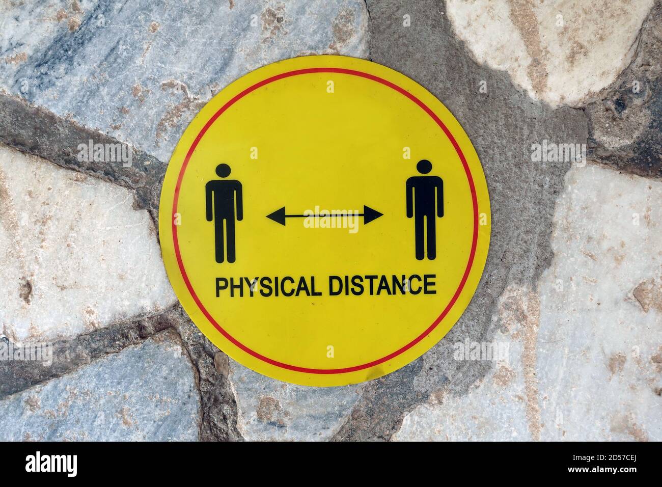 Social distancing stand here floor sign. Coronavirus safety precautions. Stock Photo