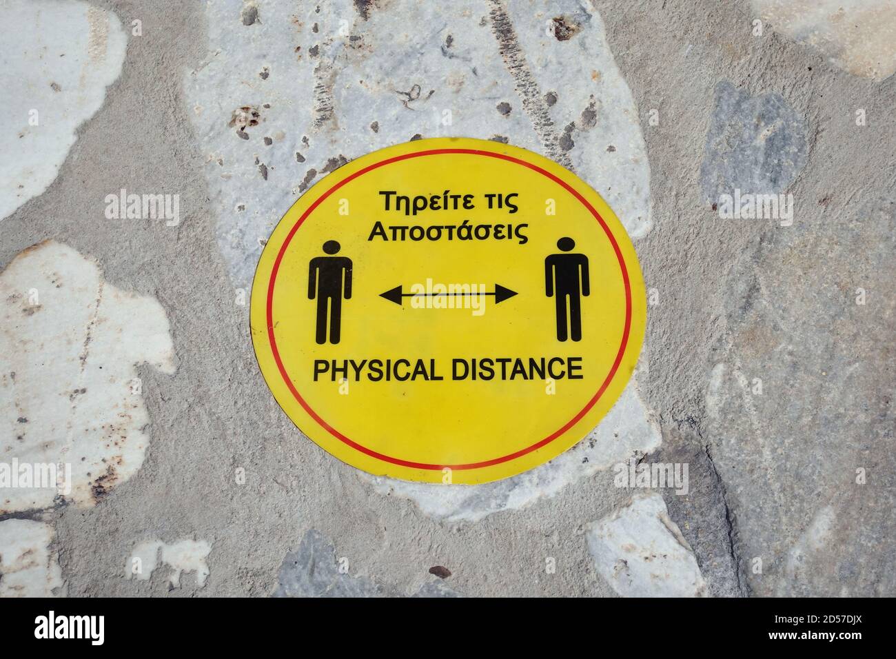 Social distancing floor sign in Greek and English text. Safety measures during the coronavirus pandemic. Stock Photo