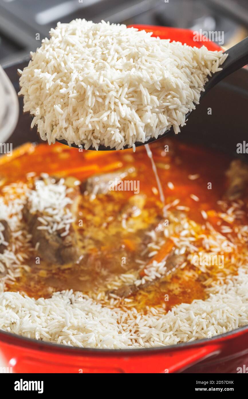 Adding rice to Pilaf. The last stage og Pilau cooking process Stock