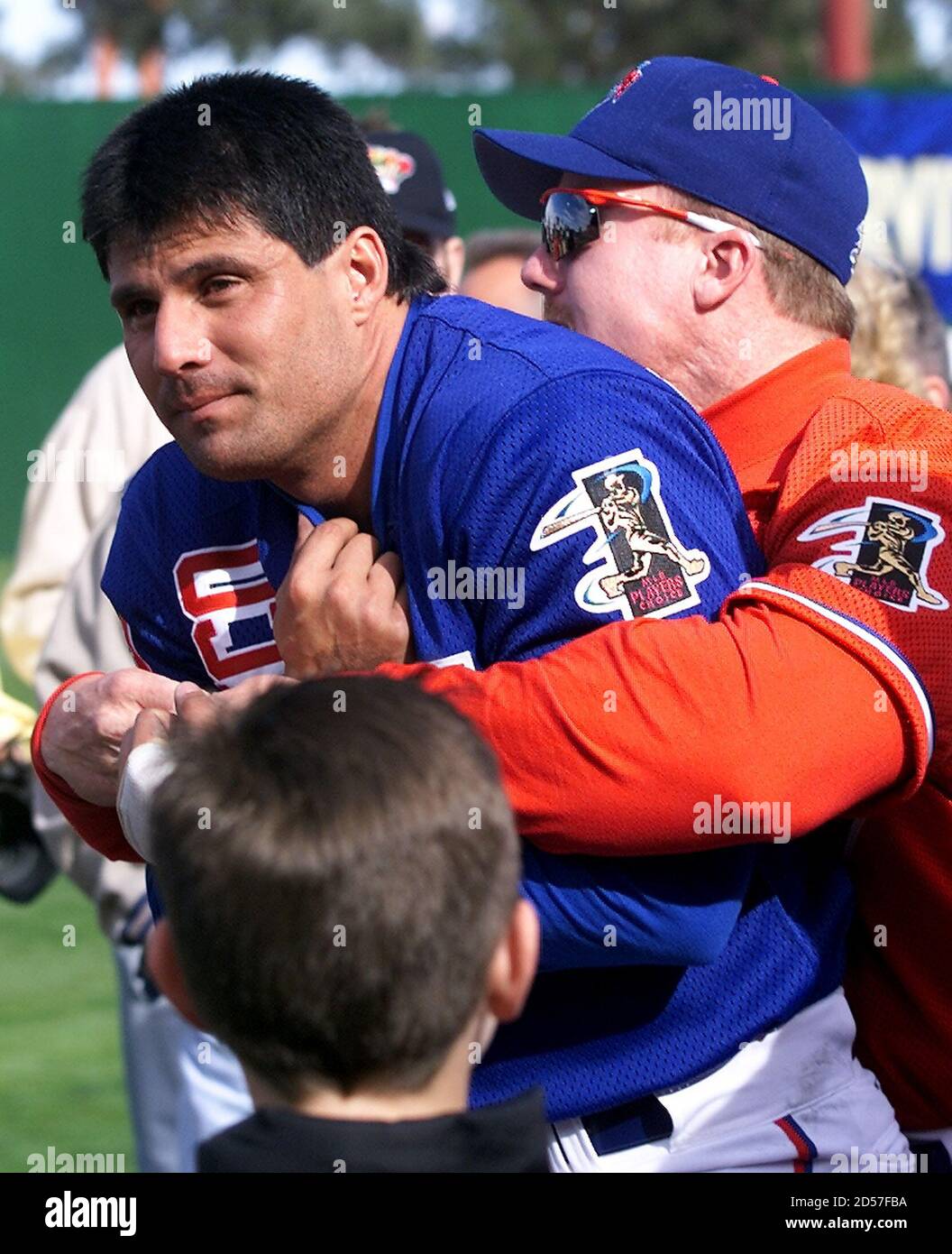 LAV06D:SPORT-BASEBALL:LAS VEGAS,NEVADA,12FEB00 - Tampa Bay Devil Rays'  outfielder Jose Canseco (L) is caught in a playful bear hug by St. Louis  Cardinals first baseman Mark McGwire as the players enter the field