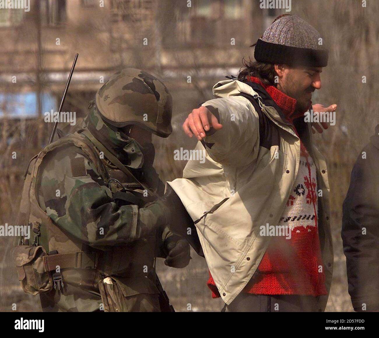 A French soldier checks a man for weapons on the main bridge of the divided city of Kosovska Mitrovica 24 February. The Kosovo peace keeping force said on Thursday it was pulling reinforcements out of strife-torn Mitrovica as calm returned and France committed to sending more troops. Stock Photo