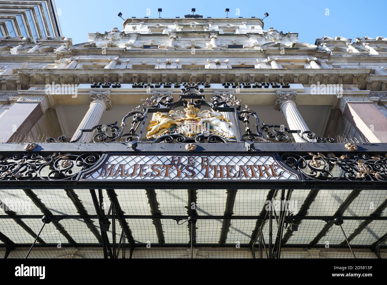London, UK. - 11 Oct 2020: The canopy and royal coat of arms in front of Her Majestys Theatre in Haymarket. The The present building dates from 1897. Stock Photo