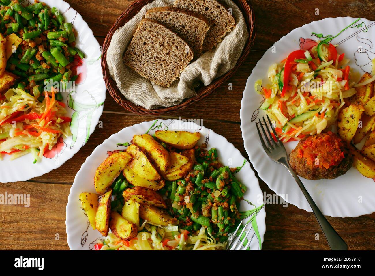 A simple meal on a plate at a diner. Salad, fried potatoes and meat cutlet. Quick and delicious lunch Stock Photo