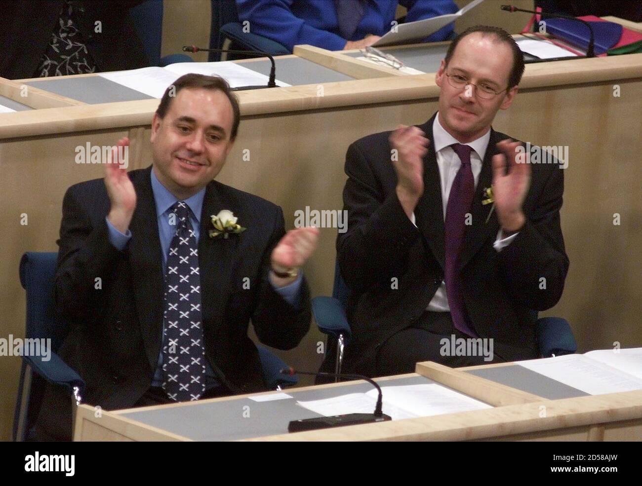 Scottish National Party leader Alex Salmond (L), with deputy John Swinney,  clap as The Queen opens the Scottish Parliament in the parliament chamber,  Edinburgh, July 1. Today's ceremonies mark the official opening