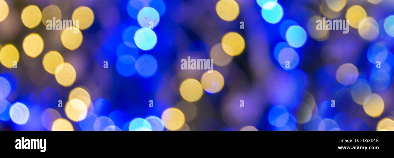 Blue and gold bokeh holidays lights at night, christmas and new year party panoramic web banner background Stock Photo