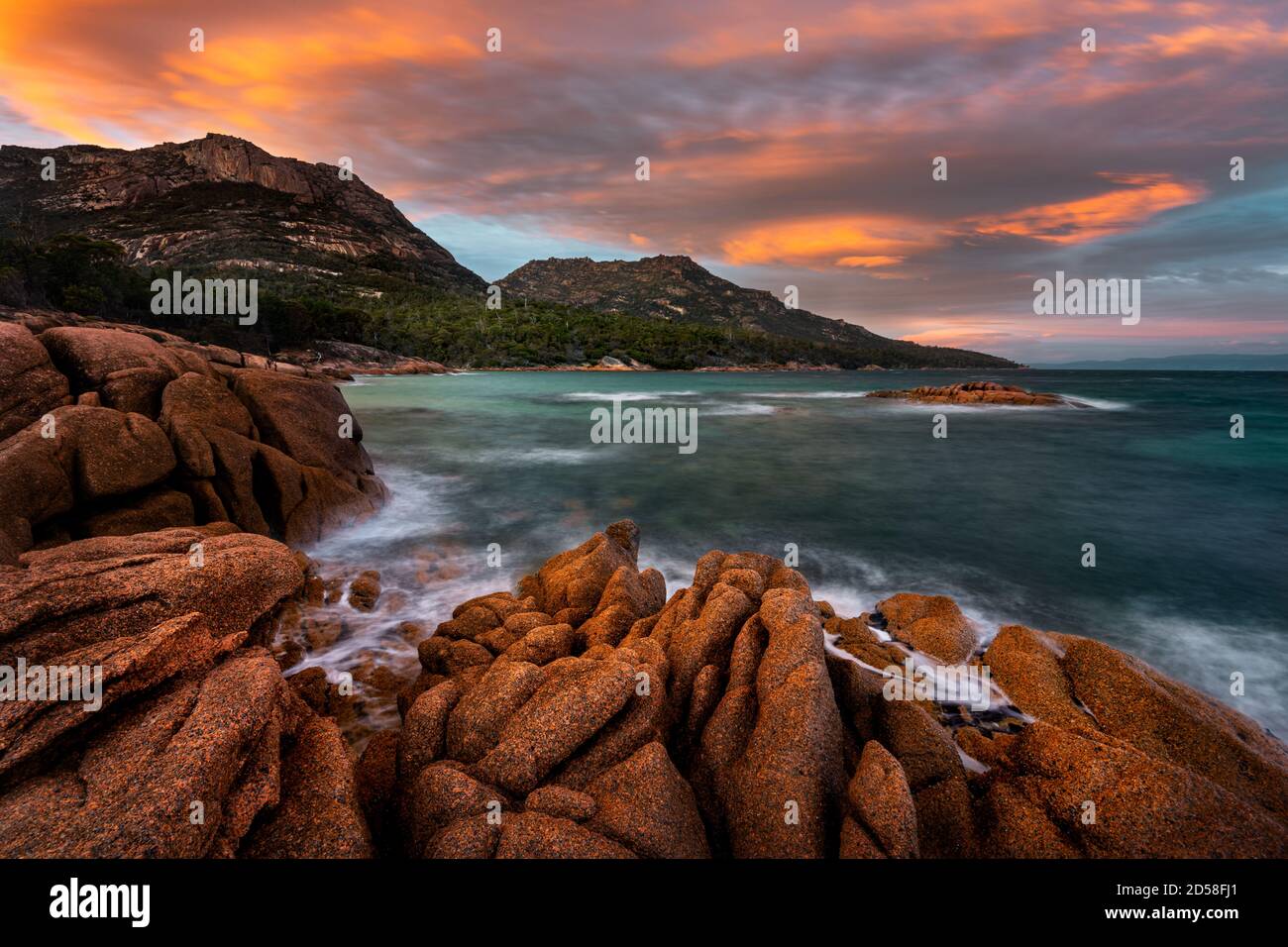 Colourful sunrise at Honeymoon Bay in Freycinet National Park. Stock Photo