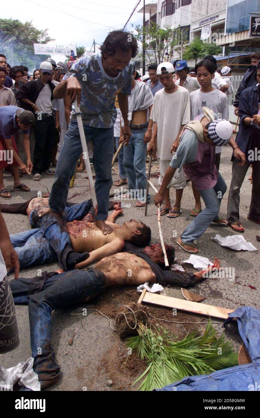 Members of an Indonesian Moslem mob walk over and abuse the bodies of three Indonesian Ambonese in Jakarta's Chinatown November 22. At least four people were killed and troops fired warning shots as a small crowd set fire to a Catholic church in central Jakarta. The clash comes after bloody anti-government protests a week ago that killed at least 14 people.  PDN/JJ/KM Stock Photo