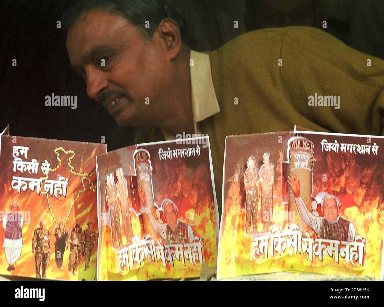 An Indian shopkeeper arranges greeting cards showing Prime Minister Atal  Behari Vajpayee with nuclear flames in the background at the capital of  Uttar Pradesh state December 26. The cards, a reminder of