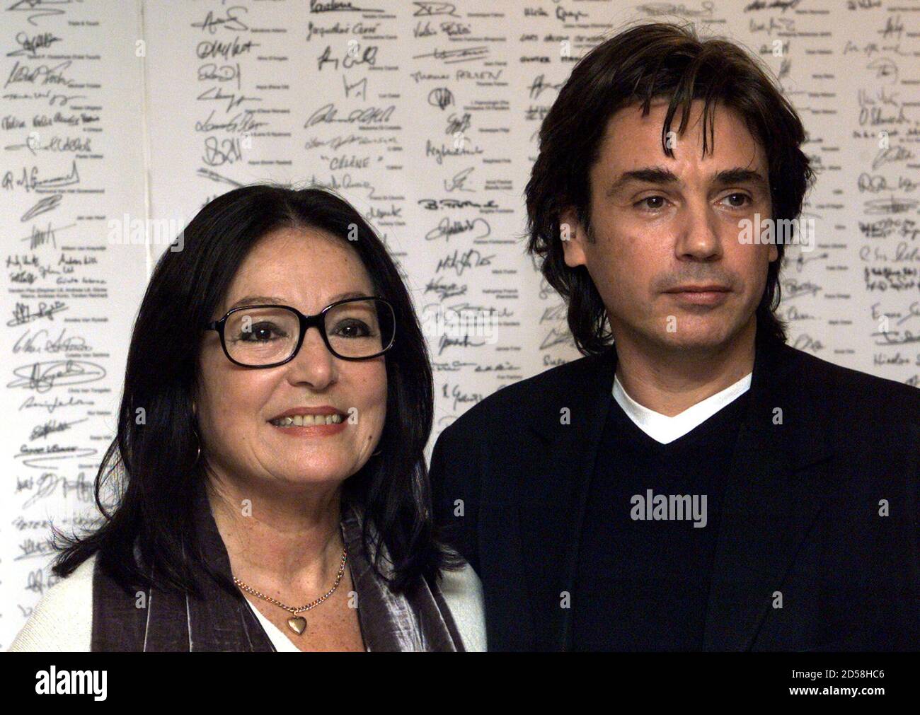 French artist Jean-Michel Jarre (R) and Member of the European Parliament  Nana Mouskouri (L) pose in front of a petition carrying the signatures of a  wide range of local, national and international