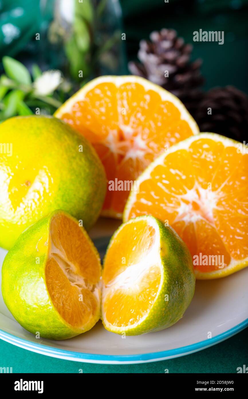 Slices of mandarine on ceramic dish. Stock Photo