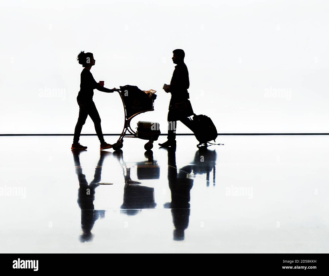 Silhouette of man and woman with luggage at an airport Stock Photo - Alamy