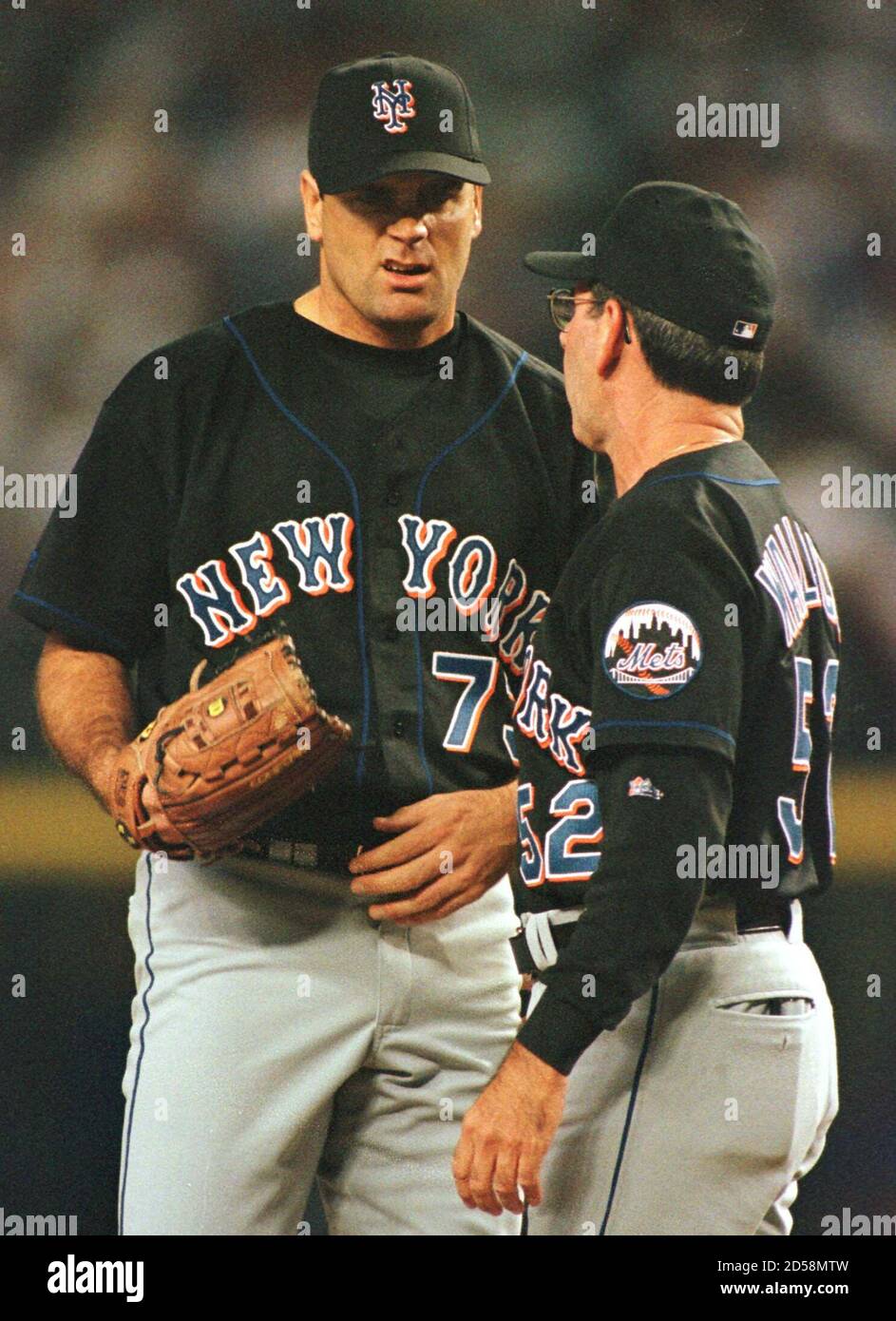 New York Mets' pitcher Kenny Rogers grimaces as he is visited on the mound  by Mets pitching coach David Wallace during the Arizona Diamondbacks' three  run third inning in Game 2 of