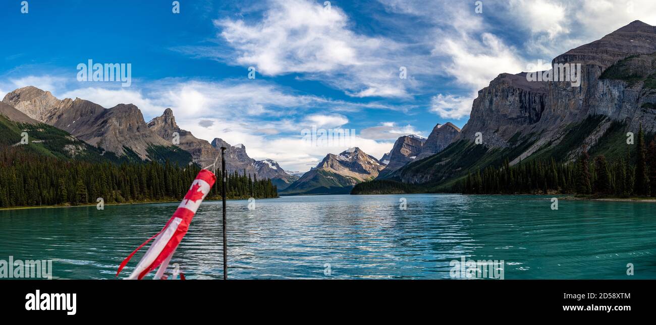 Canadian flag on a boat on Lake Maligne with Hall of the Gods in the distance, Canadian Rocky Mountains, Alberta, Canada Stock Photo