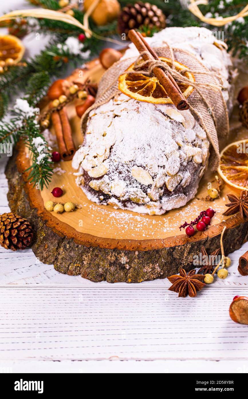 German Stollen Christmas cake on a rustic chopping board with Christmas decorations Stock Photo