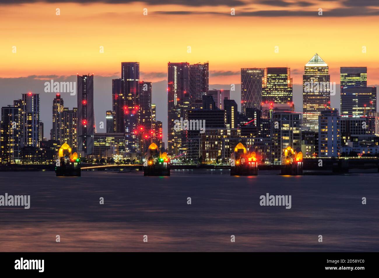 Thames Barrier in front of Canary Wharf at dusk, London, England, UK ...