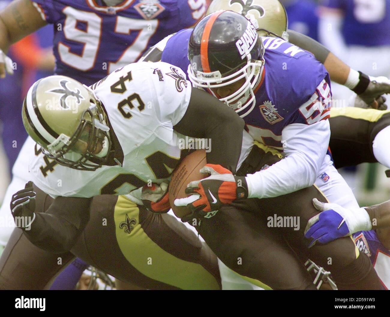 New Orleans Saints rookie running back Ricky Williams (34) is caught from  behind by New York Giants linebacker Marcus Buckley (55) during action in  the second quarter of their NFL game, October