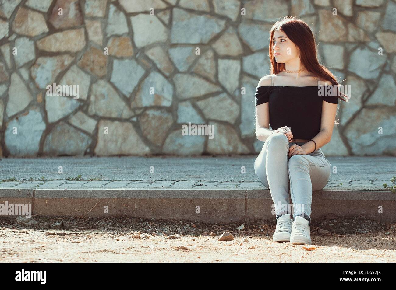 Portrait of a teenage girl sitting on the kerb, Spain Stock Photo