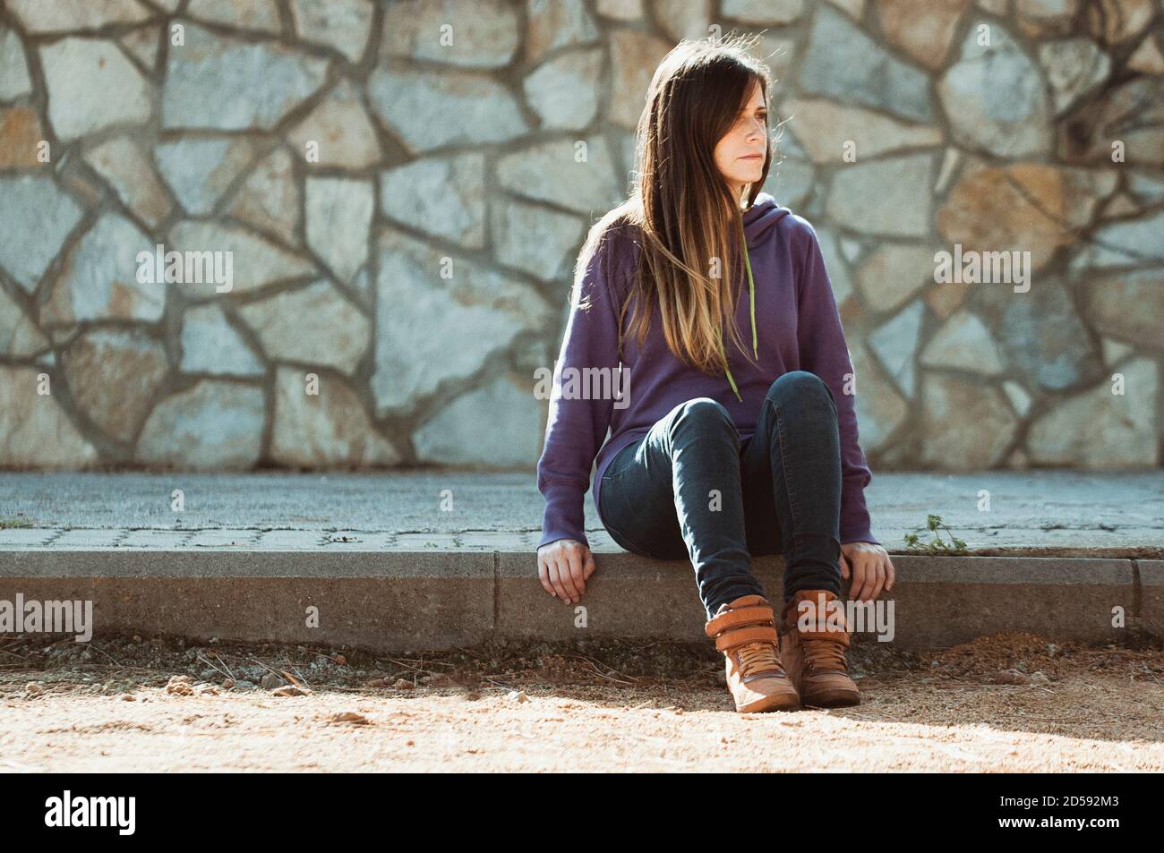 Portrait of a woman sitting on the kerb, Spain Stock Photo