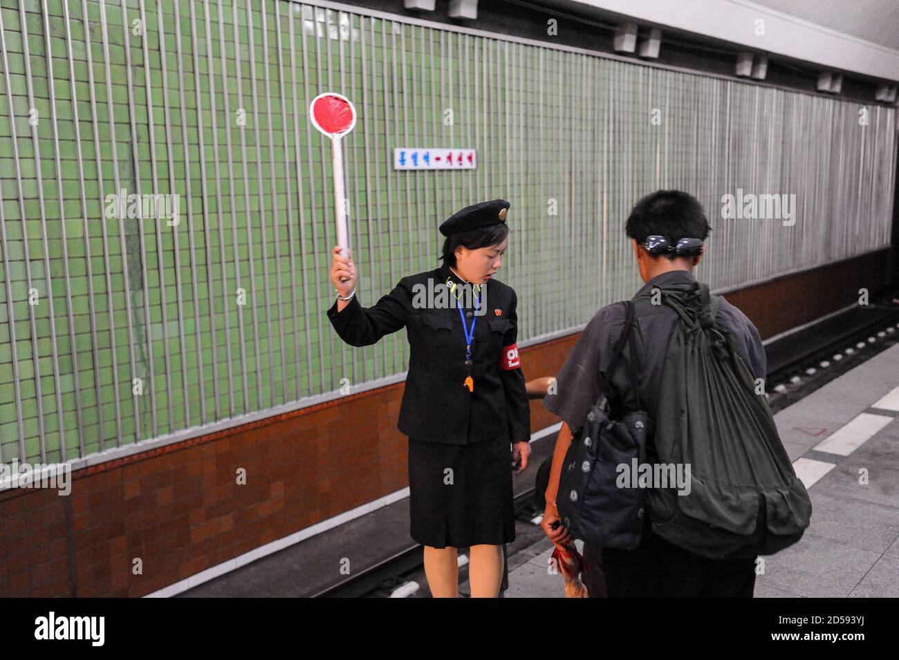 09.08.2012, Pyongyang, North Korea, Asia - A female platform attendant signals at an underground station of the Pyongyang Metro in the capital city. Stock Photo