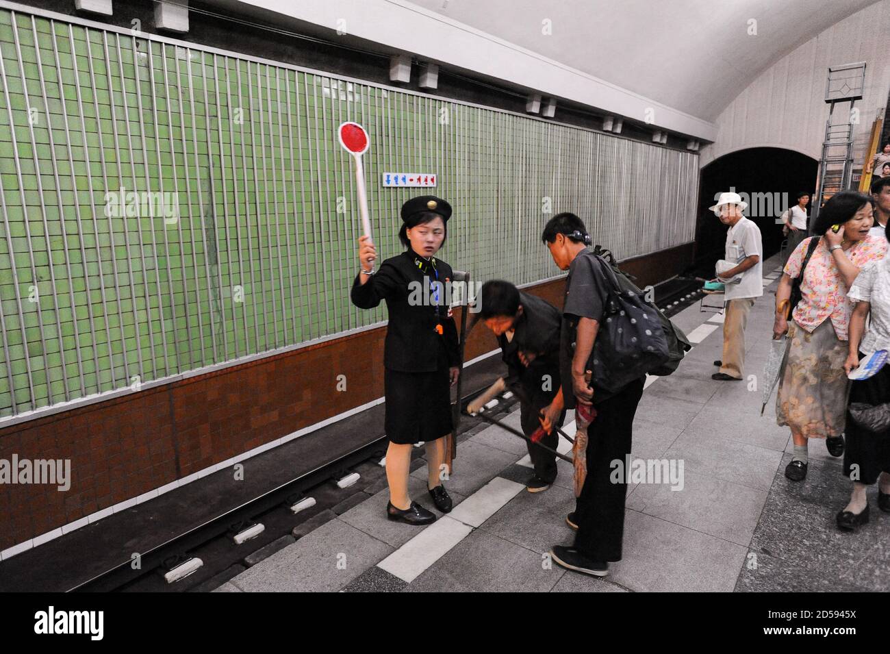 09.08.2012, Pyongyang, North Korea, Asia - A female platform attendant signals at an underground station of the Pyongyang Metro in the capital city. Stock Photo
