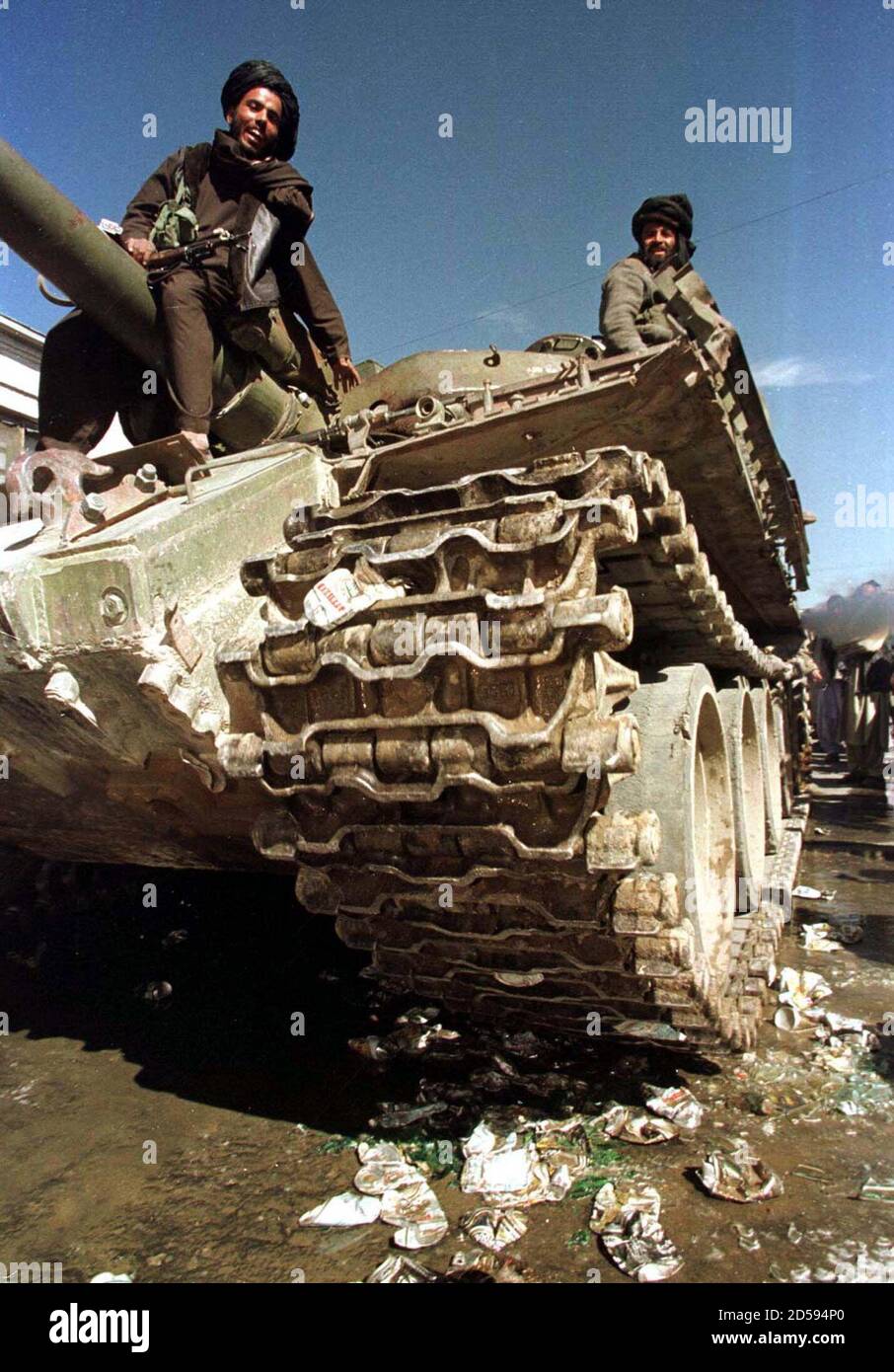 Afghanistan's purist Islamic Taliban fighters laugh from their battle tank as they crush beer cans to demonstrate their loathing of alcohol October 24. The tank drove over the cans a dozen times, spraying beer over bystanders. The Taliban did not say where the beer had come from, saying only it had been seized. Stock Photo