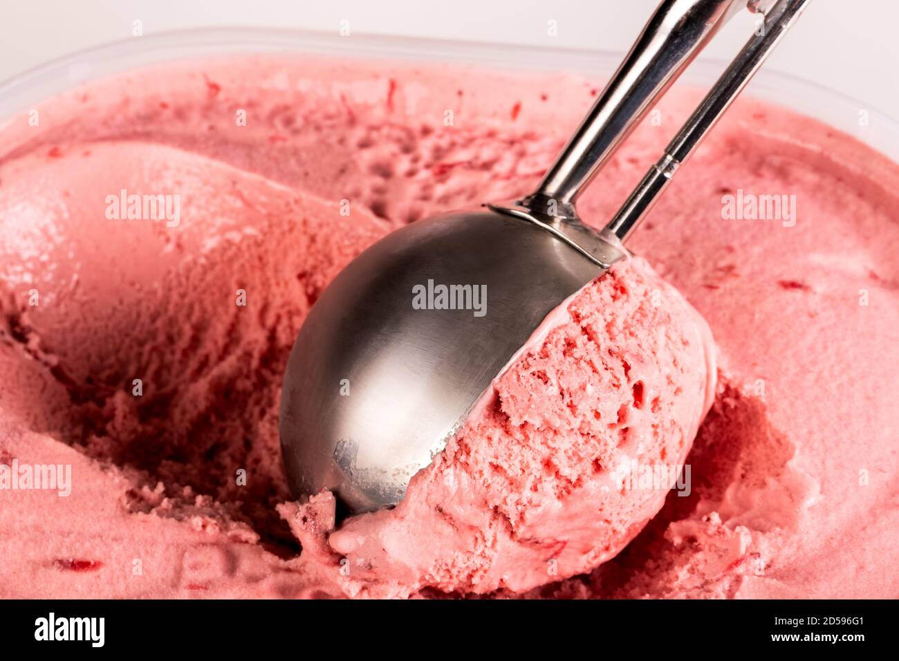 Close up of strawberry ice cream being balled up ready to serv. Stock Photo