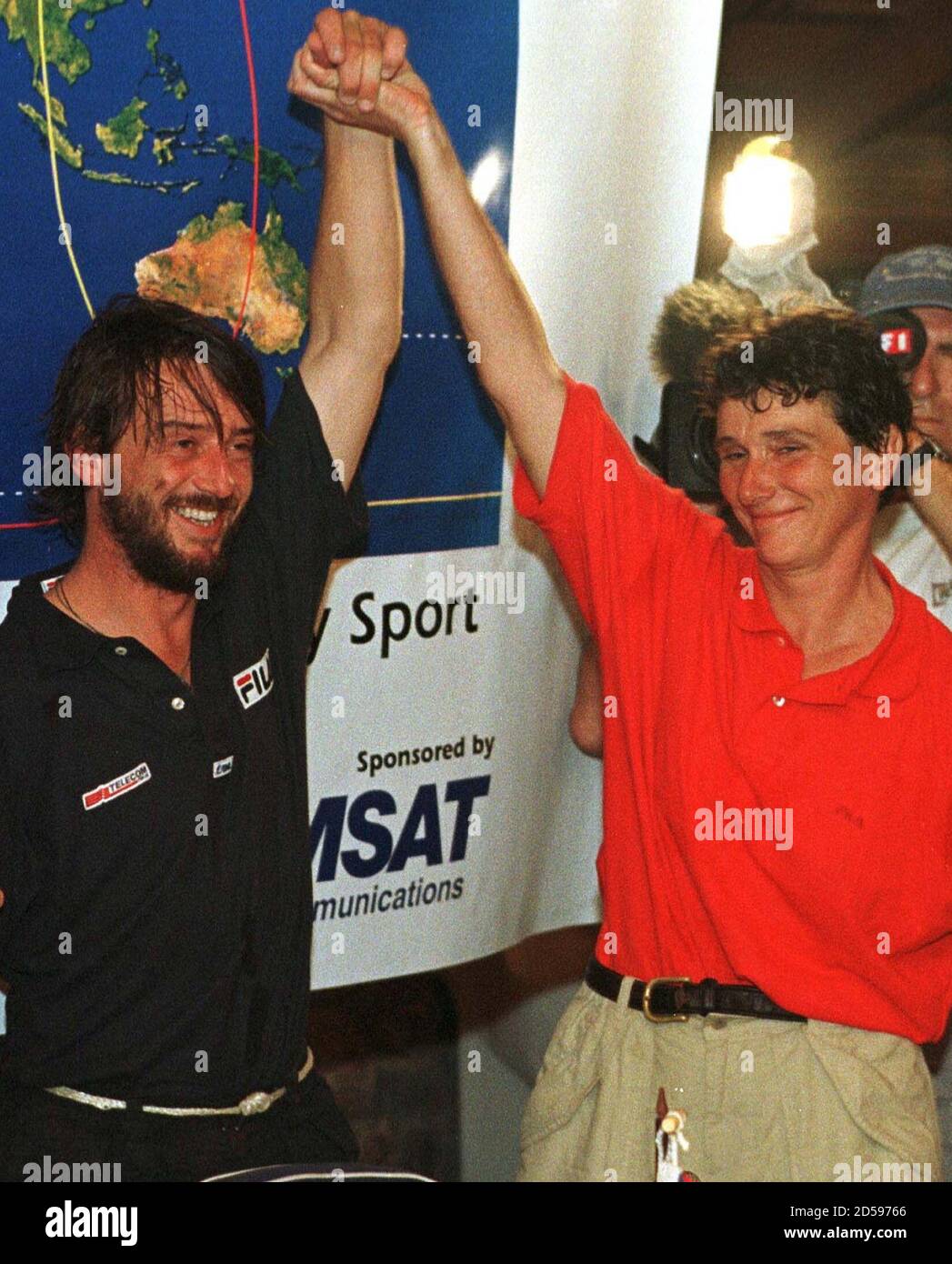 Italian skipper Giovanni Soldini (L) and his French colleague Isabelle  Autissier raise their hands at the begining of a news conference after  their arrival at Punta del Este on the boat Fila,