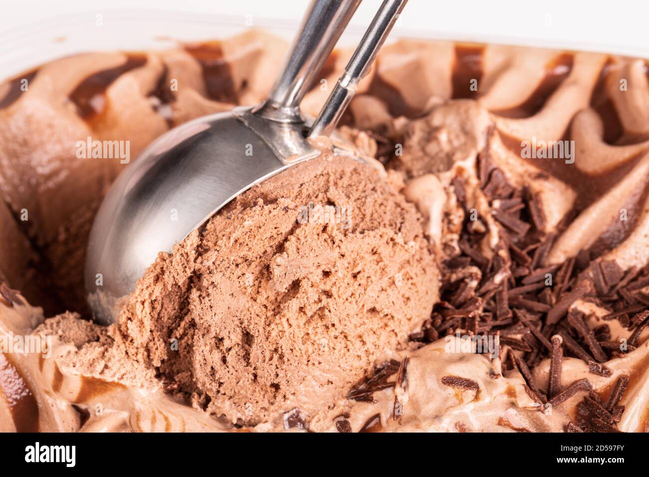 Close up of a mechanical ice cream scoop gathering up ice cream to be served. Stock Photo