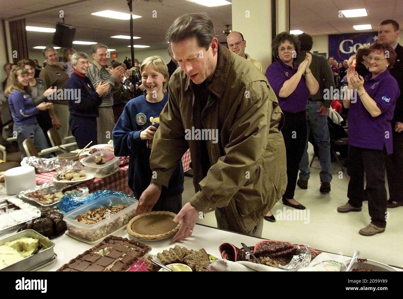 Democratic presidential candidate U.S. Vice President Al Gore gets a round  of applause as he places his pumpkin pie on the table during a campaign  stop "pot-luck" dinner at the United Auto