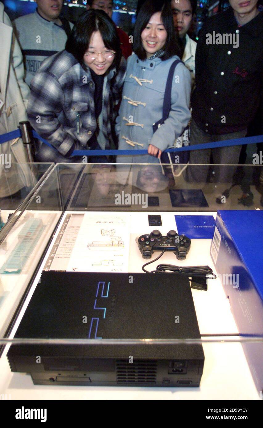 Japanese visitors look at a glass-encased PlayStation 2 video game console  on display at PlayStation Festival 2000, an event marking the release of  Sony's new game unit in Makuhari, east of Tokyo