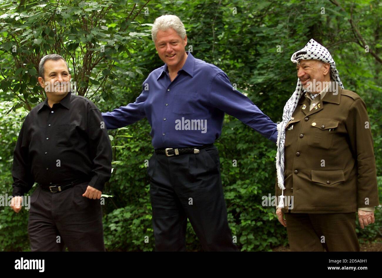 President Clinton leads Israeli Prime Minister Ehud Barak (R) and  Palestinian President Yasser Arafat (L) to the Laurel cabin on the grounds  of Camp David during peace talks, July 11. ,The summit