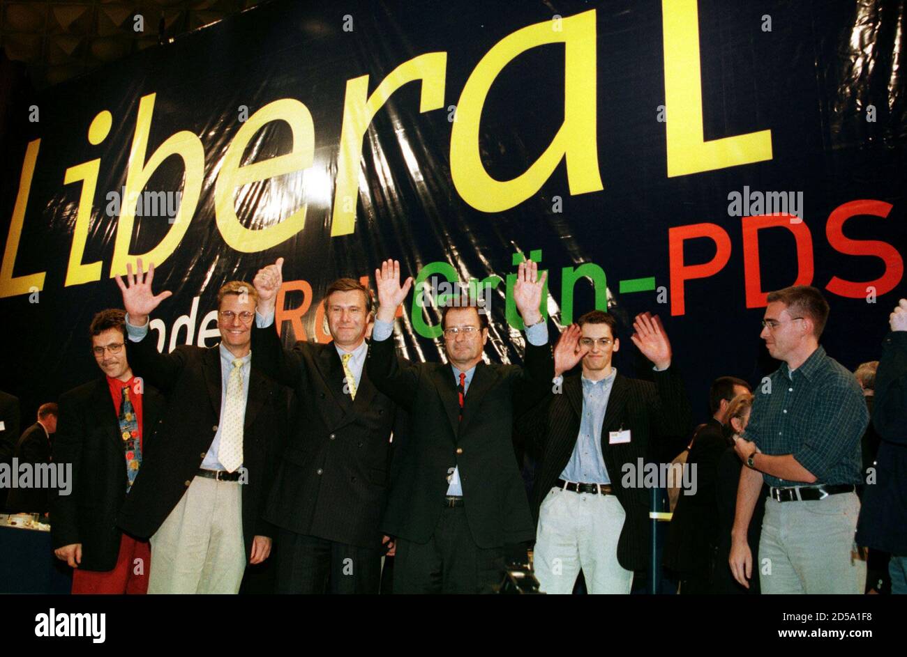 FDP party manager Guido Westerwelle, Free Democratic party (FDP) Wolfgang Gerhardt and German Foreign Minister Klaus Kinkel (LtR) wave to delegates accompanied by party members in front of an election poster reading ' Liberal or Red-Green-PDS (Party of Democratic Socialism) '  at a one-day party congress in Bonn, August, 29. The FDP is launching a massive drive for 'second votes' in the final stages of their election campaign to reach the five percent threshold in Germany's general elections on September 27. Stock Photo