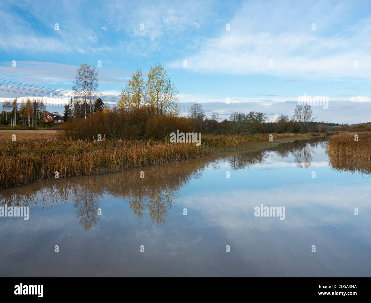 Sipoo/Finland - OCTOBER 12, 2020: A beautiful rural scene casting reflections on the calm river surface. Stock Photo