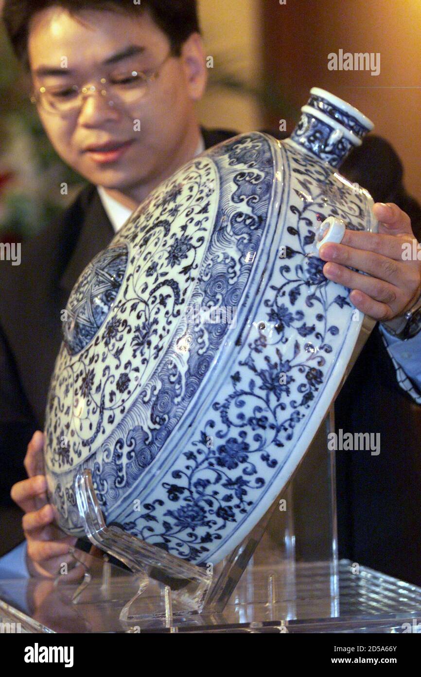 Jason Tse, director of chinese ceramics department at Sotheby's, displays an extremely rare, large blue and white flask from the Yongle period of Ming dynasty (AD 1403 - 1424) in Hong Kong November 1. The flask, measuring 47.2cm in height, has fetched HK$21,470,000 (US$2,773,902) at Sotheby's sale of chinese ceramics in the territory on Monday, breaking a world auction record for chinese blue and white porcelain.  BY/DL Stock Photo