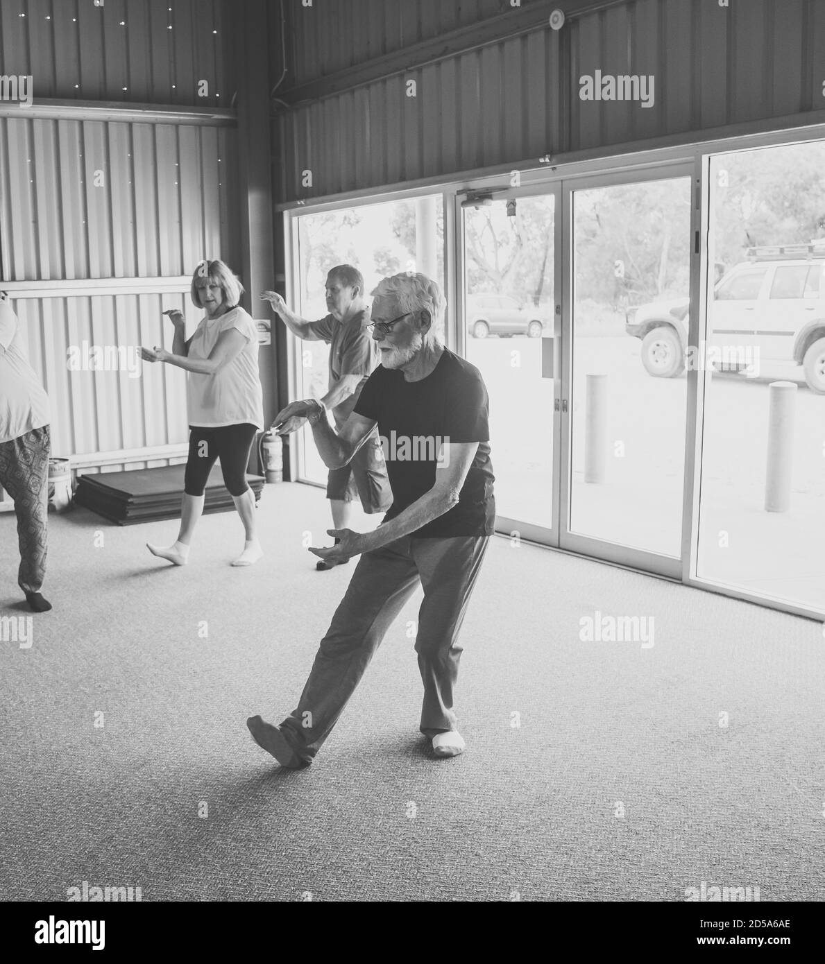 Group of seniors in Tai Chi class exercising in an active retirement lifestyle. Mental and physical health benefits of exercise and fitness in elderly Stock Photo