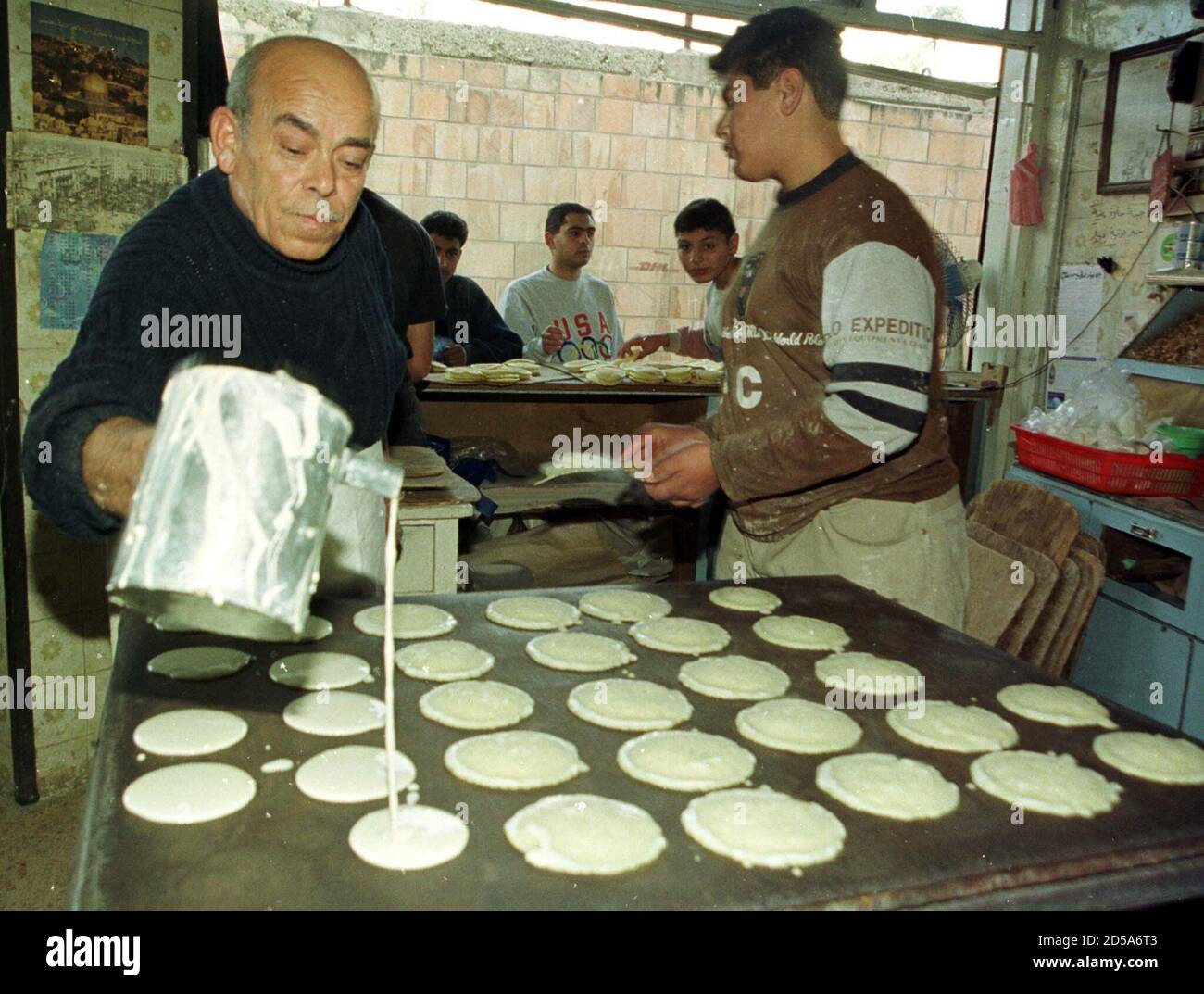 Famous Jordanian sweet maker Abu Ali (L) prepares "katayef", the