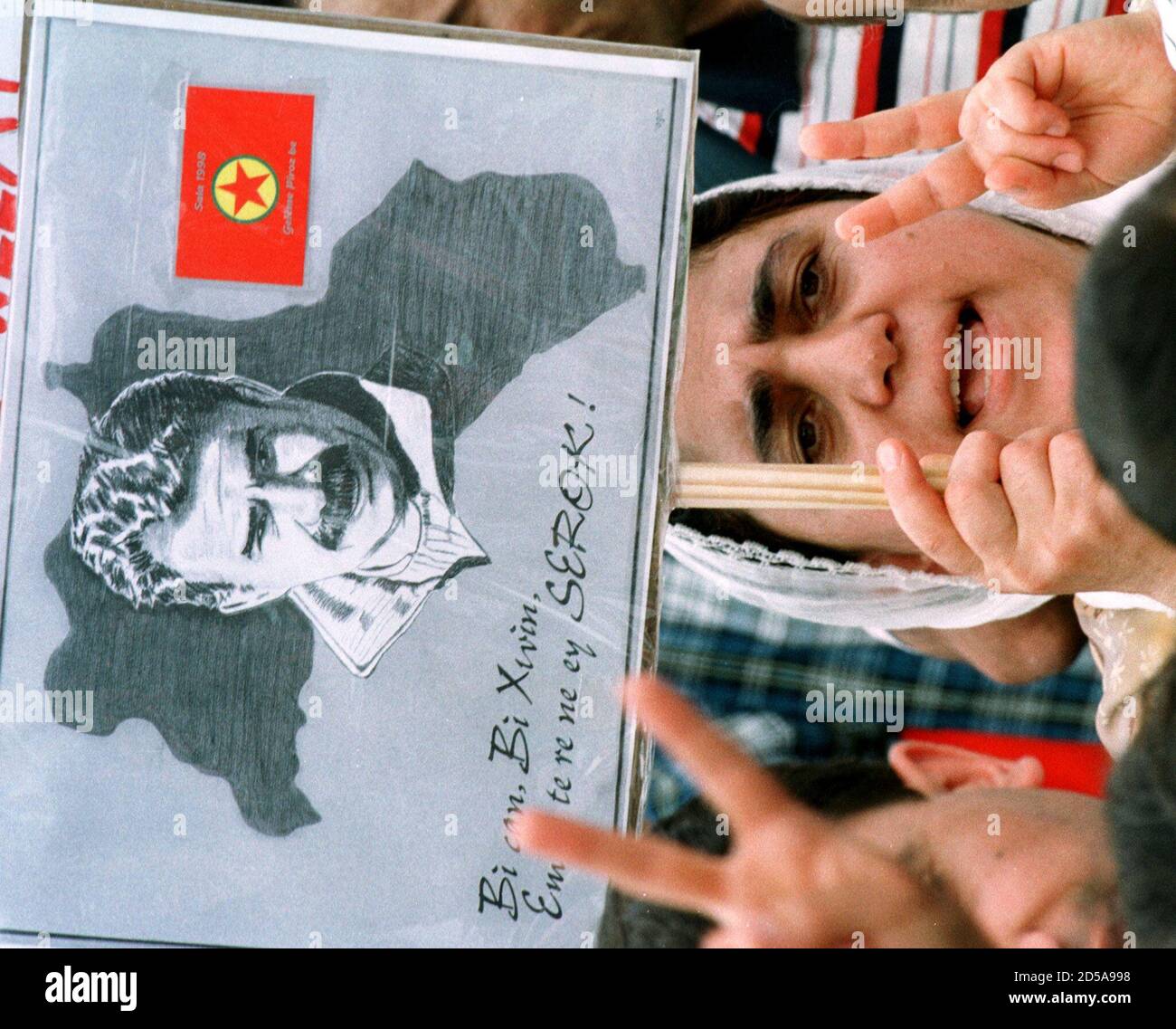 A Kurdish woman gestures as she holds a poster showing a picture of the  leader of the illegal Kurdish Workers Party (PKK) Abdullah Oecalan during a  peaceful demonstration in Dortmund June 6.