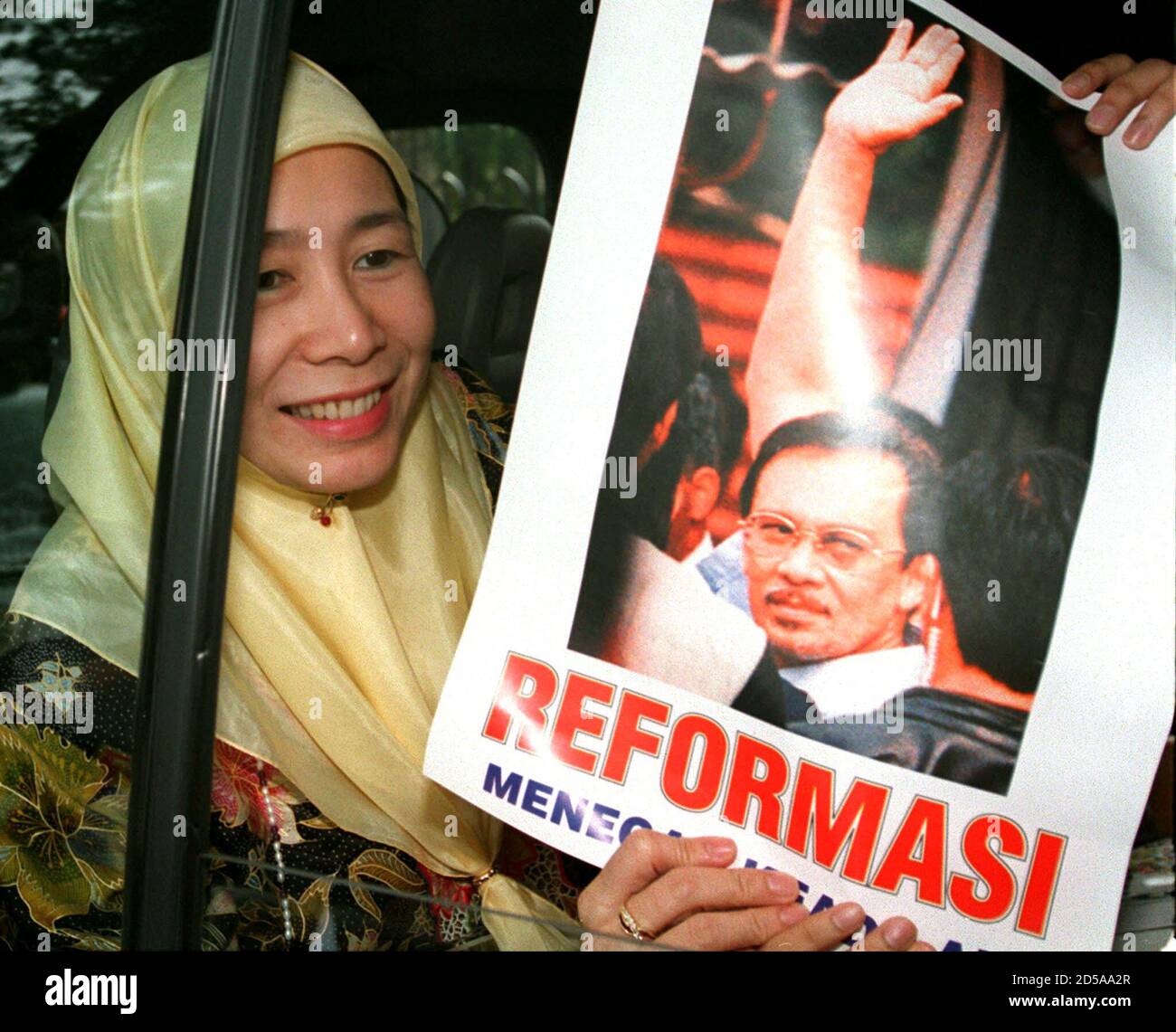 Wan Azizah Wan Ismail Wife Of Sacked Malaysian Finance Minister Anwar Ibrahim Smile As She Shows A Poster Of Anwar While Leaving The Malaysian High Court In Kuala Lumpur December 9 Anwar